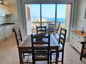 una cucina con tavolo e sedie e vista sull'oceano di Apartamento Llançà, 2 dormitorios, 4 personas - ES-170-22 a Llança