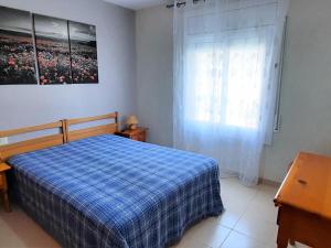 - une chambre avec un lit bleu et une fenêtre dans l'établissement Apartamento Llançà, 2 dormitorios, 5 personas - ES-170-44, à Llançà