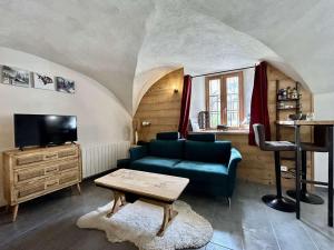 a living room with a couch and a tv at Appartement Le Monêtier-les-Bains, 3 pièces, 4 personnes - FR-1-330F-222 in Le Monêtier-les-Bains