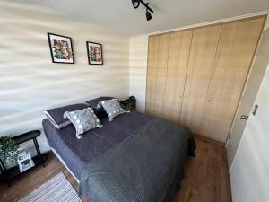 a bedroom with a large bed with two pillows at Departamento Royal Suite 2 Chillan - Centro - Factura - Empresa - Parking - wifi in Chillán