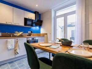 a kitchen with a wooden table and green chairs at Villa face à la mer avec terrasse privative, confort moderne, Wi-Fi gratuit à Saint-Nazaire - FR-1-306-1260 in Saint-Nazaire