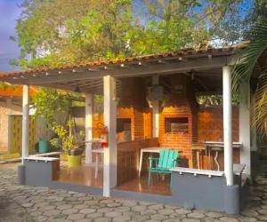 - un pavillon avec une table et des chaises sur la terrasse dans l'établissement Casinha da Rena em Cambury, à São Sebastião