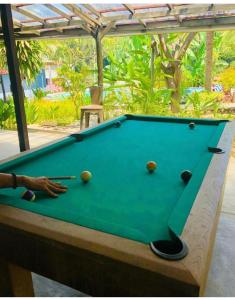 a pool table with a person holding a cue at Wae Molas Hotel in Labuan Bajo