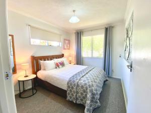 a bedroom with a bed and a window at Rathlin Cottage in Twizel