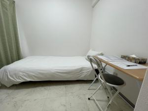 a bedroom with a bed and a desk and a chair at A&C STAY Shin-Osaka83 in Osaka