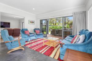 sala de estar con sillas azules y mesa en All Inn en Rotorua