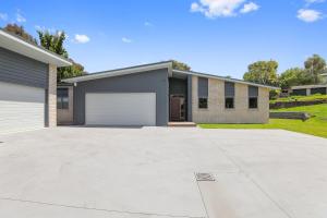 uma casa com uma entrada e uma garagem em All Inn em Rotorua