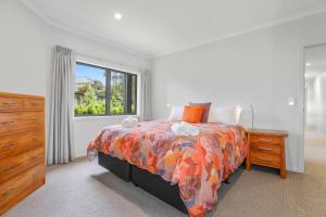 ein Schlafzimmer mit einem Bett, einer Kommode und einem Fenster in der Unterkunft All Inn in Rotorua