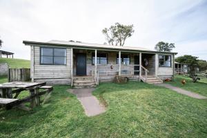 a small wooden house with a picnic table in front of it at The Ranch Mornington Peninsula in Boneo
