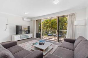 Santa Monica Apartments - Hosted by Burleigh Letting في غولد كوست: غرفة معيشة مع أريكة وتلفزيون