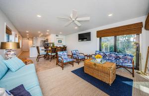 sala de estar con sofá azul y sillas en Beachfront Aldea 11 en Clearwater Beach