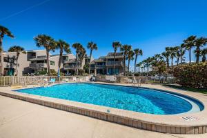 una piscina con palmeras y casas en Beachfront Aldea 11 en Clearwater Beach