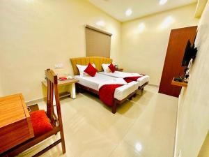a bedroom with two beds with red pillows at Sunlight Residency in Chennai