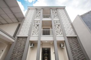 a white building with a balcony on it at SUPER OYO 3350 Cozy Residence Syariah in Malang