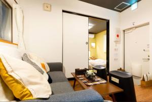 een woonkamer met een bank en een tafel bij Shikitsunishi 2-10-14 - Vacation STAY 12162 in Osaka