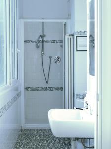 La salle de bains blanche est pourvue d'un lavabo et d'une douche. dans l'établissement FiorDiLuna, nel cuore di Brescia, à Brescia