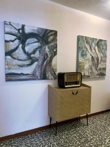 a tv sitting on a dresser next to a painting at FiorDiLuna, nel cuore di Brescia in Brescia