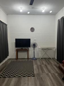 a living room with a television and a table at CFD Homestay 1 Dungun in Dungun