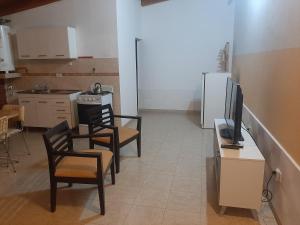 una cocina con 2 sillas y TV. en Departamento La Mariposa en Perito Moreno