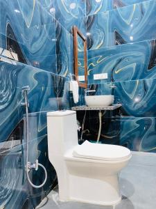 La salle de bains est pourvue de toilettes et d'un mur bleu. dans l'établissement Jasmer Haveli, à Jaisalmer