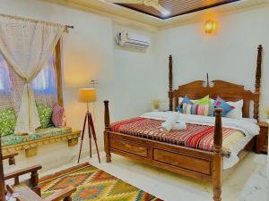 - une chambre avec un grand lit en bois et une fenêtre dans l'établissement Jasmer Haveli, à Jaisalmer