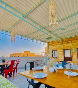 eine Terrasse mit einem Holztisch und Stühlen in der Unterkunft Jasmer Haveli in Jaisalmer