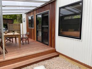 eine Holzterrasse mit einem Tisch an einem Haus in der Unterkunft Marlo Hideaway in Marlo