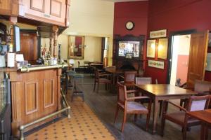 restauracja ze stołami i krzesłami oraz bar w obiekcie Mundaring Weir Hotel w mieście Mundaring