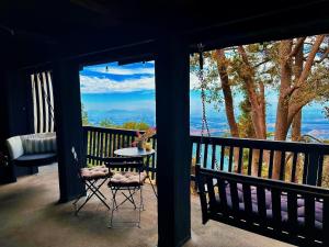 a patio with a table and chairs on a balcony at 100 Mile View-Fire Pit, Romantic, Peaceful, Private in Crestline