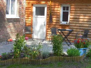 a porch with a table and chairs and flowers at Ferienhaus Kranichzauber in Klausdorf Mecklenburg Vorpommern