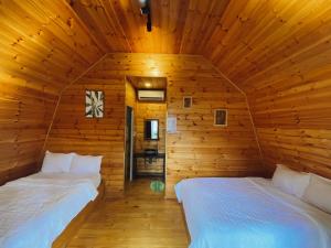 una camera con 2 letti in una cabina di legno di T'MĂNG ĐEENG HOMESTAY a Kon Von Kla