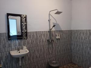 a bathroom with a shower and a sink at Tangkoko Jungle Homestay in Rinondoran