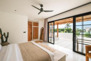 a bedroom with a large bed and a sliding glass door at Villa Sama Canggu in Canggu +42 photos