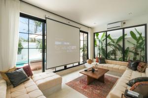 a large screen in a living room with a couch and a table at Villa Sama Canggu in Canggu