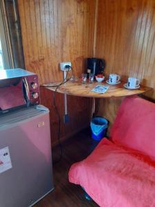 um pequeno quarto com uma mesa e um balcão com um micro-ondas em Atavai Hotel Rapa Nui em Hanga Roa