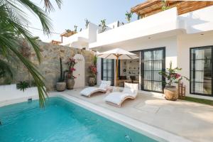 a villa with a swimming pool and a house at Villa Sama Canggu in Canggu