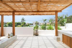 an outdoor patio with a wooden pergola at Villa Sama Canggu in Canggu
