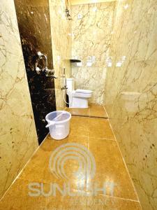 a bathroom with a toilet and a counter with a sign on it at Sunlight Residency in Chennai