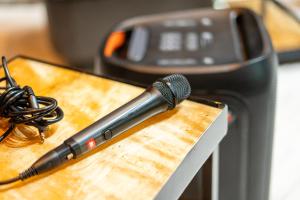 un micrófono sobre una tabla de cortar de madera en クリエイティブな人の遊び場!最大16名リンカンスタジオRINKAN Studio, en Ito