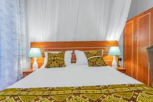 a bedroom with a large bed with two lamps at Ambrosia Heights in Entebbe