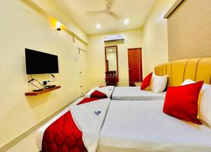 una camera d'albergo con due letti e una televisione di Sunlight Residency a Chennai