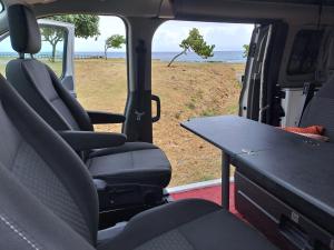 une table à l'arrière d'une camionnette avec vue sur l'océan dans l'établissement Van Vadrouil, à Saint-Pierre