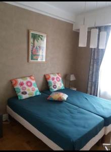 Una cama con sábanas azules y almohadas en un dormitorio en En plein coeur de Nice en Niza