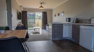 a kitchen with a table and a dining room at The Flight Pad Aisle Seat Pet Friendly in Waitara
