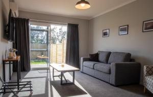 a living room with a couch and a table at The Flight Pad Aisle Seat Pet Friendly in Waitara