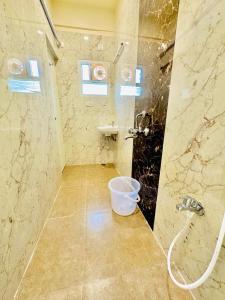 a bathroom with a shower and a bucket at Sunlight Residency in Chennai