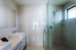uma casa de banho com 2 lavatórios e uma cabina de duche em vidro. em ABC On Wanaka Bay Support Local em New Plymouth