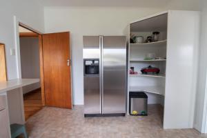 een keuken met een roestvrijstalen koelkast en planken bij Spacious In Strandon Great Value For A Family in New Plymouth