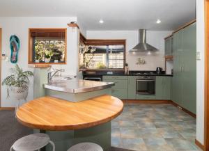 a kitchen with a sink and a wooden table at Beachfront Bliss On Wanaka Terrace Support Local in New Plymouth