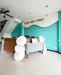 a room with a bed and two white umbrellas at Kata Sea Host in Kata Beach